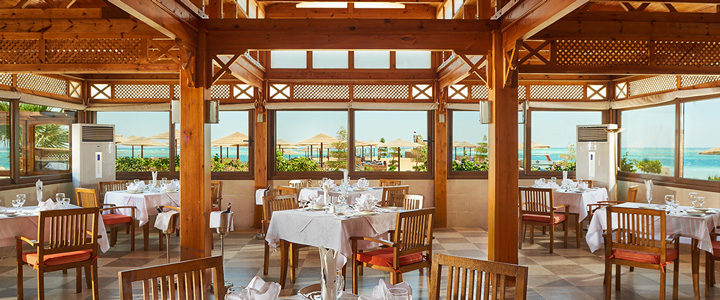 Der lichtdurchflutete Speisesaal des Sea Star Beau Rivage in Hurghada verbindet warme Holzstrukturen mit einem direkten Blick auf das Rote Meer.